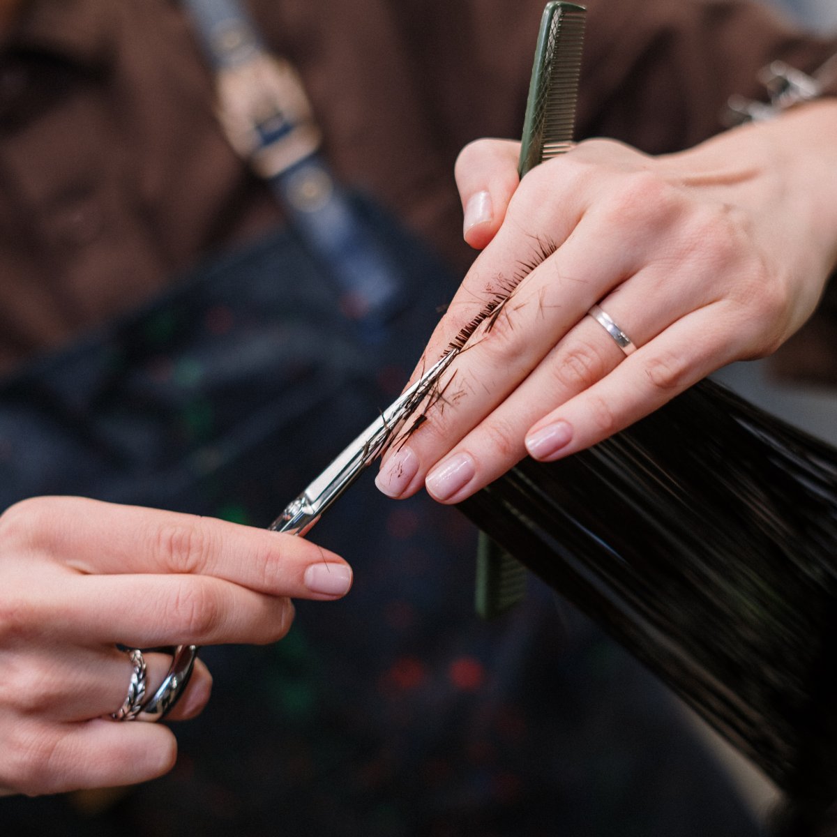 Gros plan sur les mains d'une femme en train de couper des cheveux